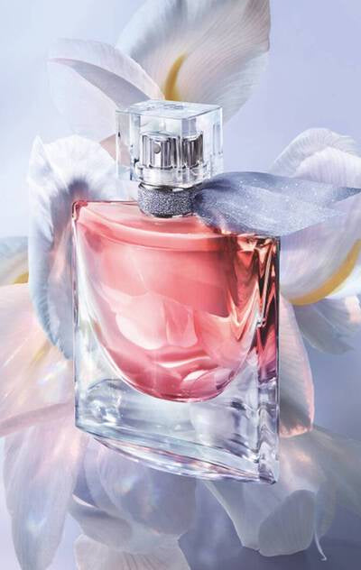 Perfume bottle with pink liquid on a soft white background