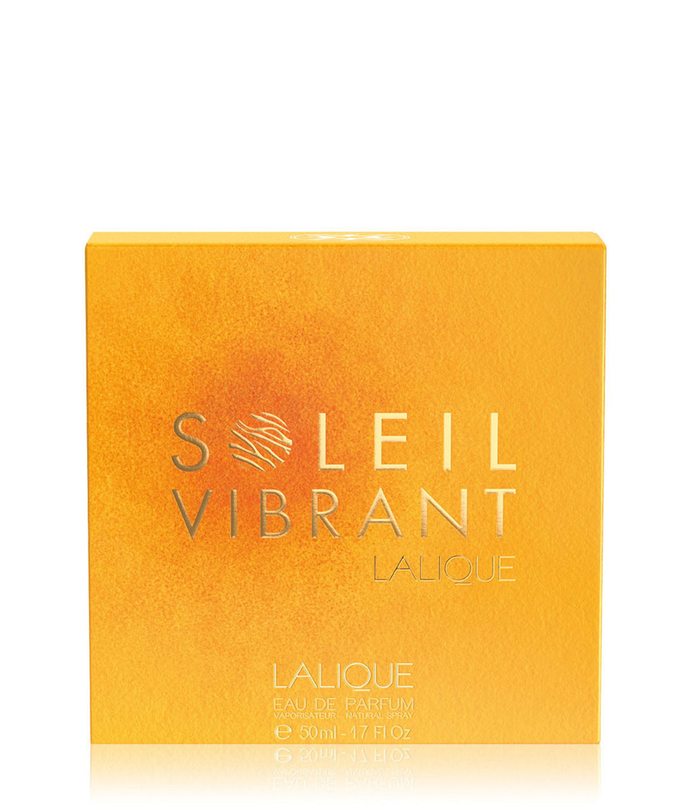 Lalique Soleil Vibrant Eau de Parfum box in a textured golden-yellow color with silver lettering, shown on a white background with a soft reflection.