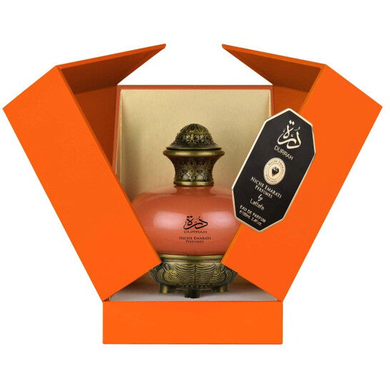 Decorative lamp with gold accents in an open orange box on a white background